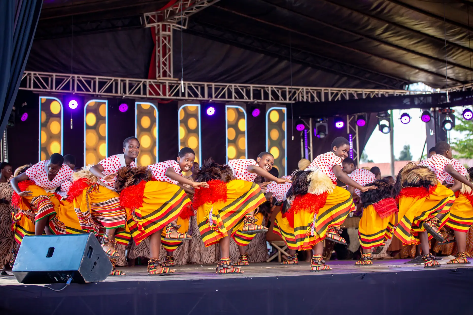Trinity College Nabbingo students performing a traditional dance on stage